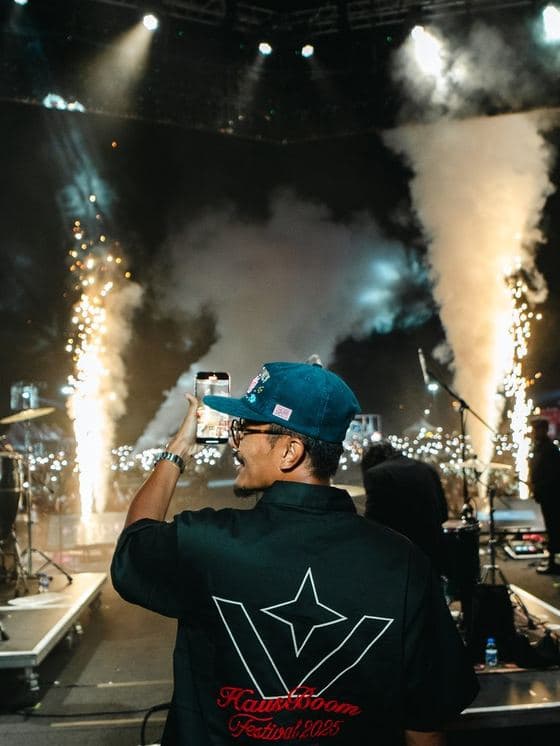 Pyrotechnics firing over a crowd at a large Malaysian music event